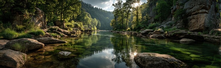 Obraz premium Serene river landscape surrounded by lush green trees and rocky formations, reflecting sunlight on calm water surface, showcasing natural beauty and tranquility in the wilderness