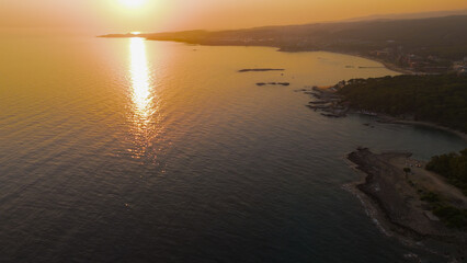 Fototapeta premium Avsallar, Alanya, Turkey. Aerial view of scenic coastline with beaches, forests, mountains and bays in warm sunset with pink tones.. Aerial View