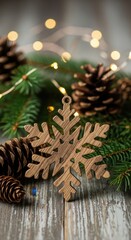 Wooden snowflake ornament with pine cones and fir branches on rustic table top.