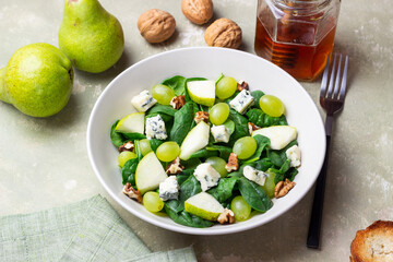 Salad with spinach, blue cheese, pear, grapes, and nuts. Healthy eating. Vegetarian.