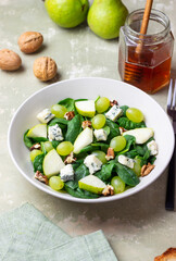 Salad with spinach, blue cheese, pear, grapes, and nuts. Healthy eating. Vegetarian.