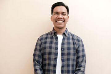 Southeast Asian man wearing flannel shirt standing and smiling expression happy, on white isolated background