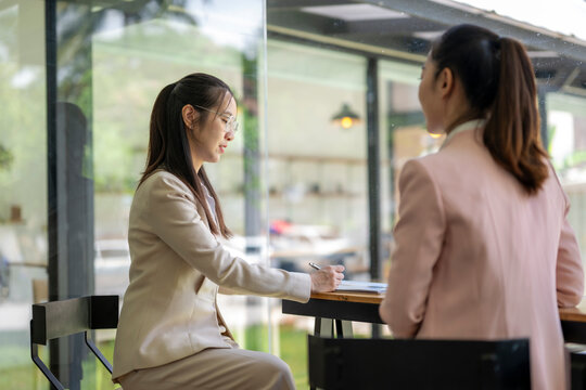 Businesswomen having a meeting, taking notes and discussing in a cafe