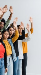 Fototapeta premium Diverse group of young adults raising hands together. Unity, teamwork and cooperation.