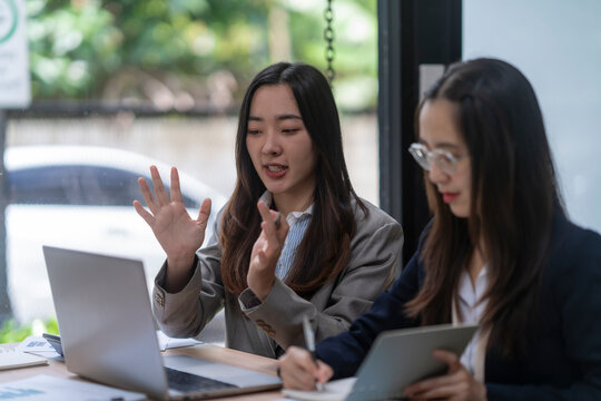Businesswomen having a video conference and taking notes in office