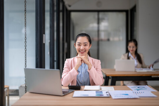 Portrait of smiling businesswoman working at desk in modern office