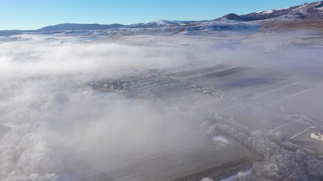 Aerial view of a misty countryside village, in early morning lights
