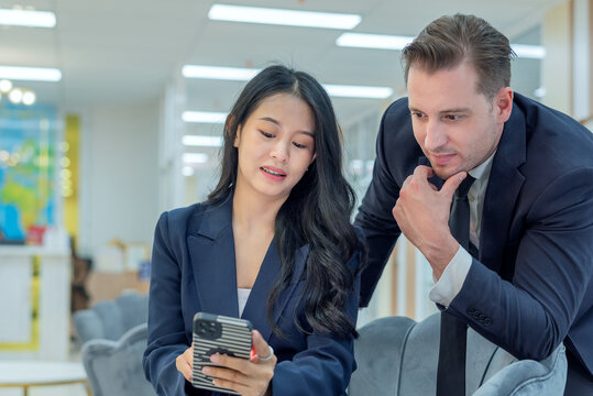 Multicultural business team collaboration diverse collaboration in office business team across cultures man woman in suits looking smartphone. team discussion business collaboration office room