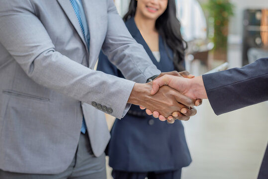 handshake diverse group teamwork meeting business professionals in suits shaking hands trust contract in an office. symbolizing agreement partnership success professional networking. - Powered by Adobe
