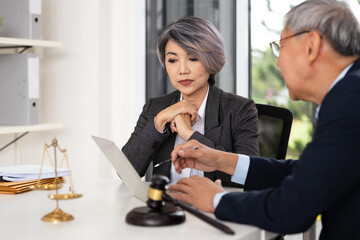 Attorney performs legal tasks to prepare cases. Lawyers at desk consulting, discussing to advise and represent client in criminal or civil proceeding, legal matter.