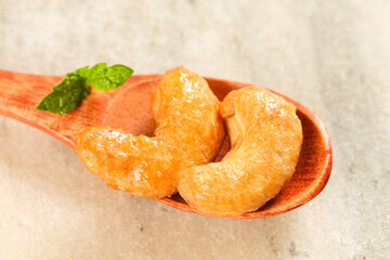 Roasted Salted Cashew Nuts in Wooden Spoon with Mint Garnish - Healthy Snack Food