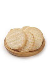 Crispy Rice Crackers on Wooden Plate - Traditional Asian Snack Food Isolated on White Background