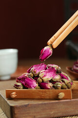 Dried Rose Buds with Wooden Tweezers for Natural Beauty Care and Herbal Tea