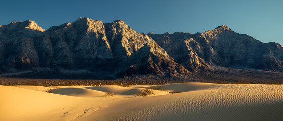 Sand Dunes Leading to Mountains Landscape on Sunny Day