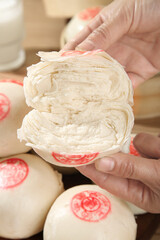 Traditional Chinese Handmade Thousand Layer Steamed Buns with Fortune Stamps Being Prepared by Hand