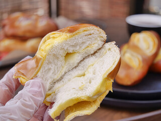 Fresh Brioche Bread with Custard Filling Held in Hand Showing Soft Layered Texture