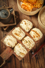 Handmade Steamed Buns with Scallion and Meat Filling on Rustic Wooden Board - Traditional Asian Home Cooking