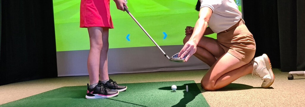 Young Golfer Receiving Instruction From Coach In Indoor Golf Simulator