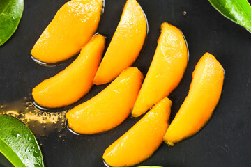 Fresh Loquat Fruit Slices from Yunnan China Alpine Region with Green Leaves on Dark Background