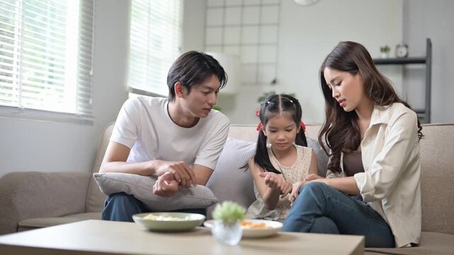 Asian parents scolding their disobedient little daughter