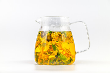 A pitcher of tea with mint leaves in it