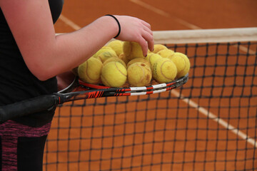 Tennis Player Holding Racket Full of Balls &ndash; Training and Preparation on Clay Court