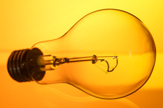 A light bulb is shown in a close up, with the bulb's filament visible
