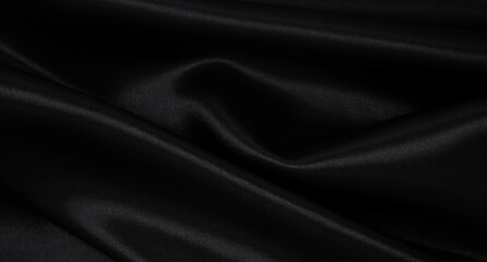 Smooth elegant black silk or satin luxury cloth texture as abstract background. Luxurious background design