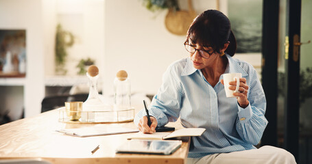 Woman, writing and notebook with coffee in home for planning, finance reminder and payment timeline. Mature person, beverage and notes for household budget, tracking expenses and financial management