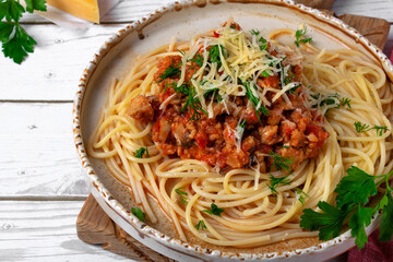 Bolognese pasta with haddock fish mince served with parmesan cheese on ceramic plate. Pescatarian meal. Variation of the classic Italian dish
