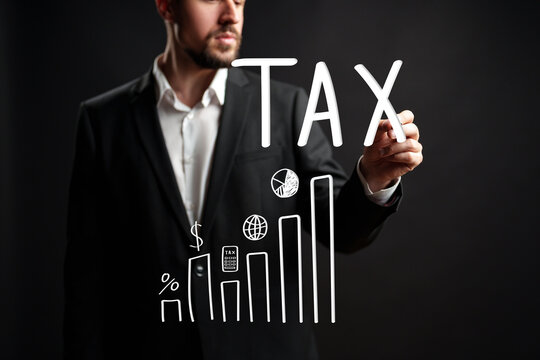 Professional man writing tax information on a black background for a financial presentation