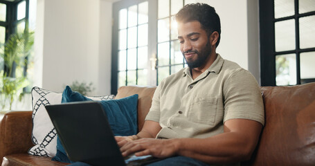 Happy, typing and man with laptop, lounge and ebook marketing on web, writer and remote work in home. Creative, brand awareness and self publisher with tech for novel promotion and person on couch