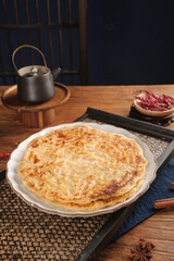 Homemade Spiced Savory Tart with Traditional Teapot on Rustic Wooden Kitchen Table