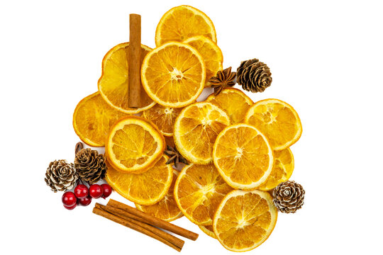 Christmas composition with dried orange slices, cinnamon, pinecones, and red berries on white background.