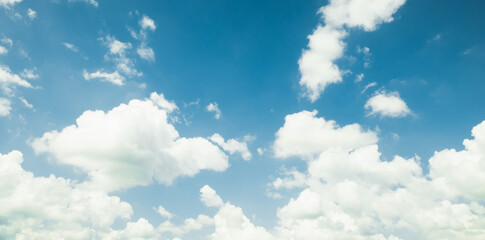 the sky is clear blue with fluffy white clouds, the sky is very bright, and the sun shines.