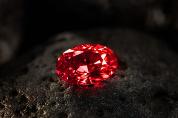 A red diamond is sitting on a rock