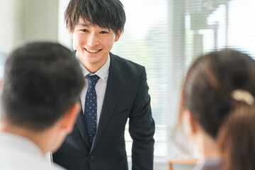 A young Asian businessman serving a couple
