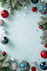 Vertical bright light blue Christmas background with a decorative border of snowy fir branches,...