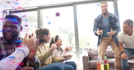 Cheering friends in casual clothes in living room holding clear snack bowl, three bottles, confetti