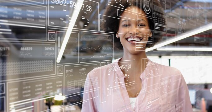 Smiling adult woman standing in tech office wearing pink blouse and white top with glass HUD