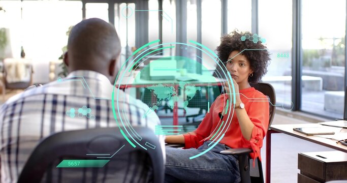Leaning woman in red blouse and jeans pondering at glass desk with holographic HUD, copy space