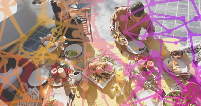 Passing plates, gathering diners wearing casual dress at yellow tablecloth on terrace, roasted bird