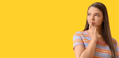 Thoughtful young woman on yellow background with space for text