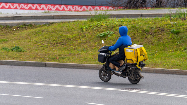 Moscow November 03, 2025, A courier on an electric bicycle delivers groceries in the city, completing their task while navigating through the streets. High quality photo