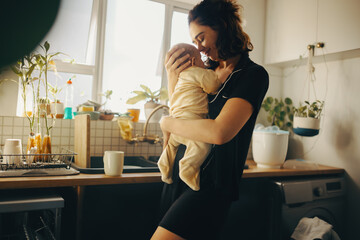 Mother holds baby in warm kitchen