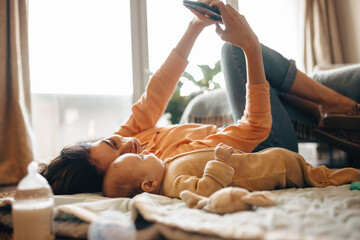 Mother and baby selfie on phone on floor