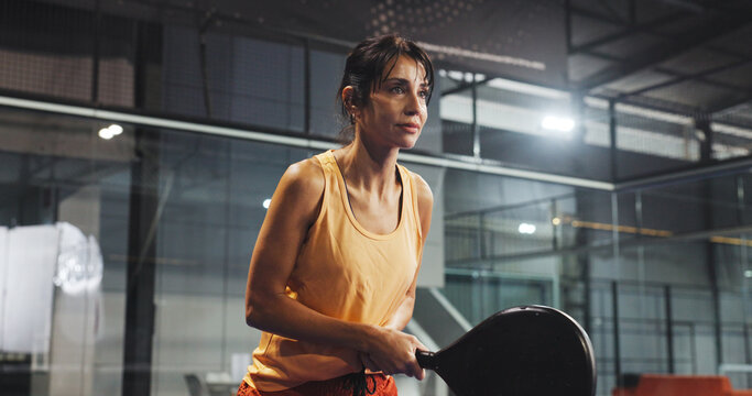 Padel, sports and woman ready for game, tournament and competition on indoor court. Tennis club, athlete and person with racket for training, exercise and workout for challenge, practice and fitness