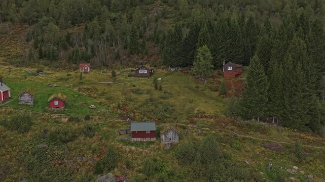 Wooden cottages on a verdant mountain ledge in Rakssetra, Norway