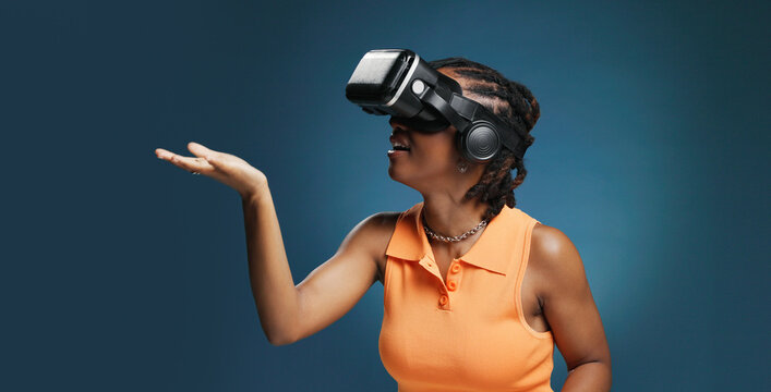 Gaming, metaverse and vr headset for black woman in studio for immersive experience. Interface, simulation and virtual reality with African user on blue background for cyberspace interaction or space