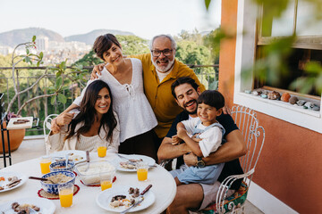 Family enjoying a Brazilian outdoor churrasco meal together on a sunny day